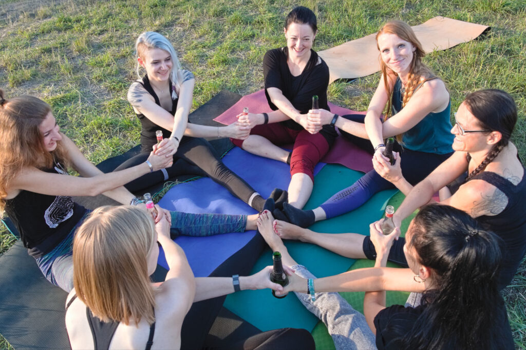 Teilnehmer des Jungesellinnenabschiedes sitzen mit der Yoga-Lehrerin im Kreis